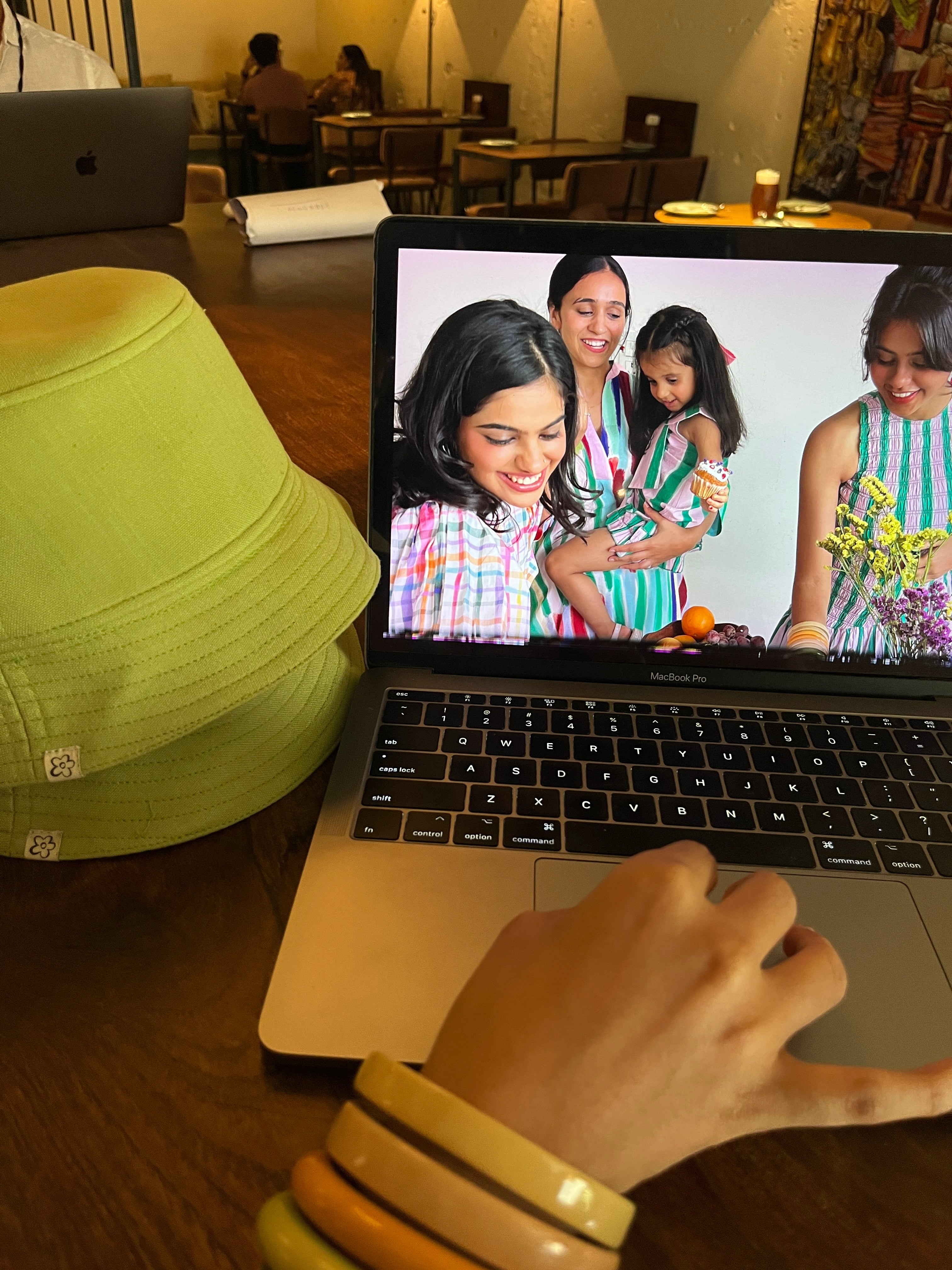 Person using a laptop displaying a video call with three women and a child.